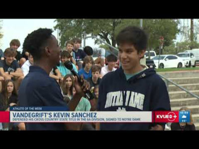 A boy in a hoodie talking to a reporter.