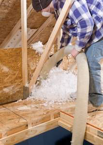 Man in attic cleaning up insulation