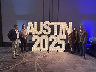 Abacus Leadership Team with Austin 2025 Glowing Sign