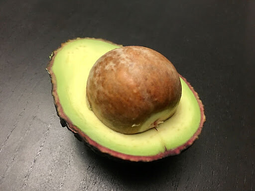 A avocado half with a seed inside 
