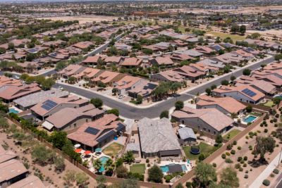 Birds eye view of an Arizona neighborhood where multiple houses have solar panels 