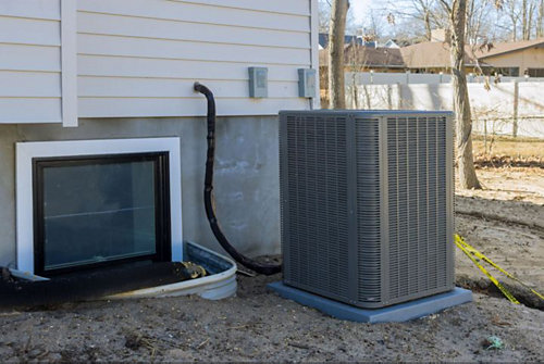 Ground AC unit situated next to a basement window.