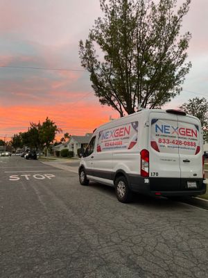 NexGen Van parked on the street with a colorful sunset