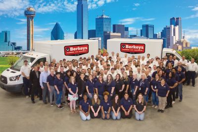 Entire Berkeys team standing in front of 2 Berkeys Trucks.