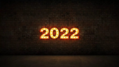 A lighted sign of 2022 on a brick wall