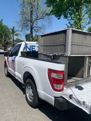 NexGen truck holding old AC condensor unit