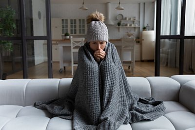 Women on her couch trying to warm up 