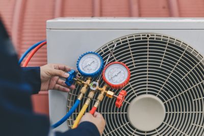 Technician checking air conditioner blowing warm air