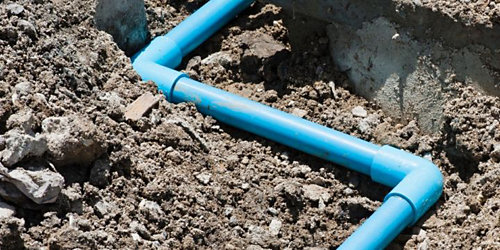 a blue pvc pipes in the dirt