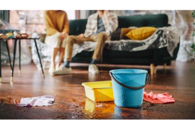 buckets on the floor catching water from a burst pipe