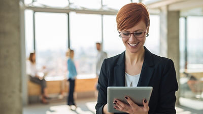 Professional woman looking down at tablet smiling