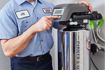Parker tech standing next to water softener