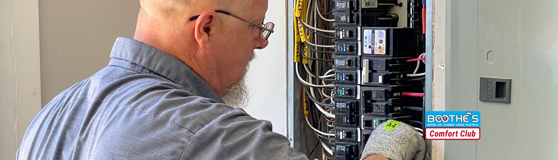 tech standing in front of electrical panel comfort club