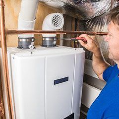 Plumber inspecting a tankless water heater