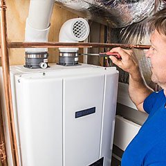 Plumber inspecting a tankless water heater