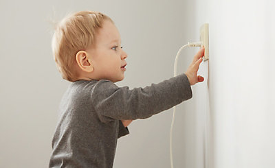Toddler reaching to touch outlet