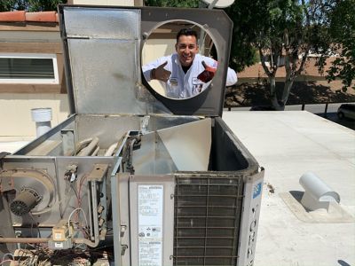 NexGen Tech givint thumbs up through AC unit