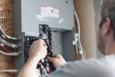 Man checking breaker box to identify an issue 