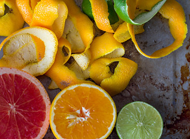 A grapefruit, orange, lime and citrus peels.