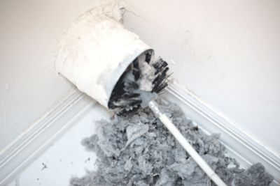 A brush cleaning a dryer vent.