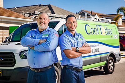 Cool Today technicians in front of a work van standing back to back 