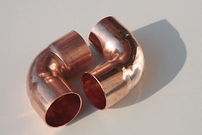 A pair of 90 degree copper pipe joints
