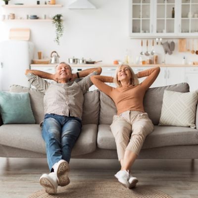 A couple sitting back on a couch relaxing