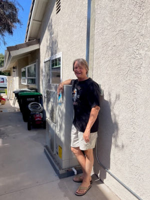 A happy man standing next to a Daikin VRV AC Unit.