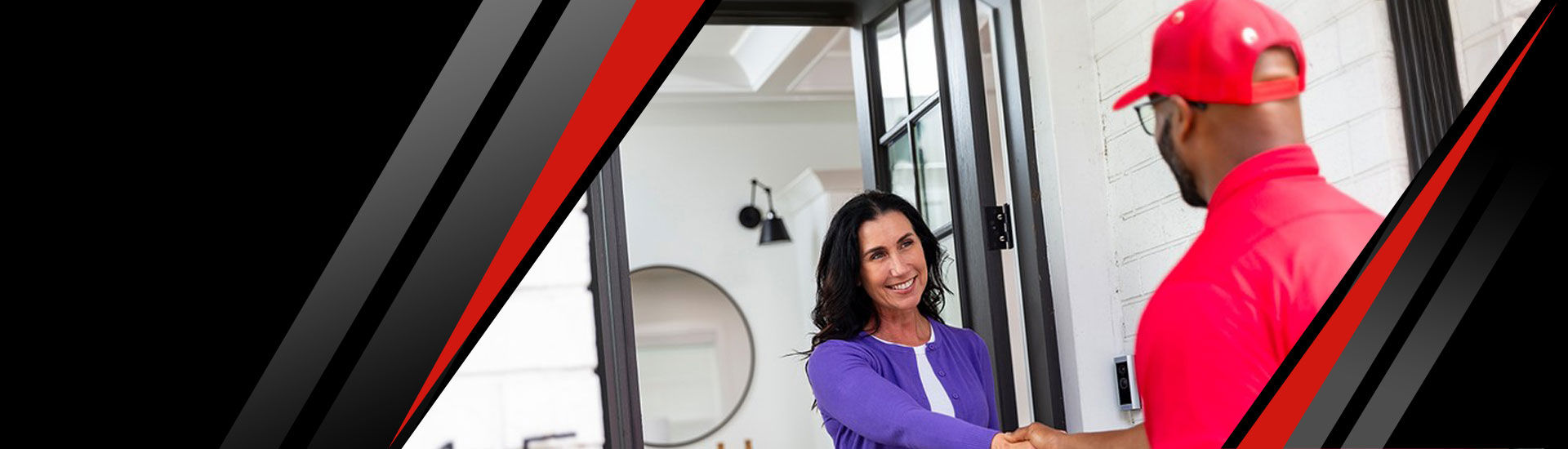 A happy customer shaking hands with a Red Cap technician at the door of her house