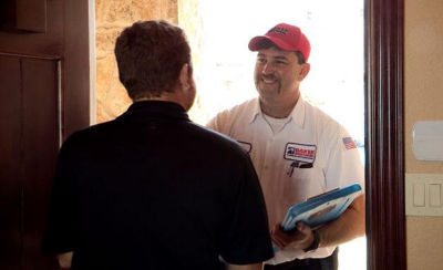 Technician smiling at customer at front door