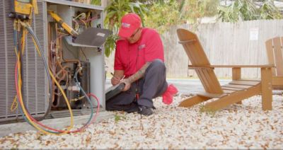 Red Cap uniformed tech diagnosing a furnace unit.