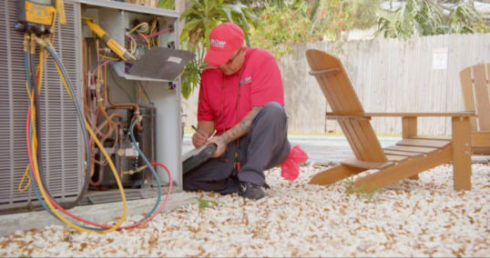 Red Cap uniformed tech diagnosing a furnace unit.