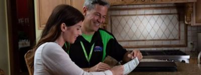 Technician discussing an air conditioner warranty with client - Williams Comfort Air Heating, Cooling, Plumbing & More