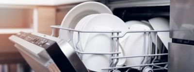 open dishwasher with clean dishes at home kitchen