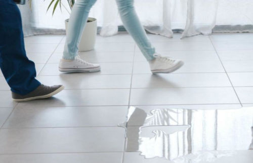A pair of feet walking on a tile floor