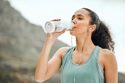 women drinking from a water bottle 