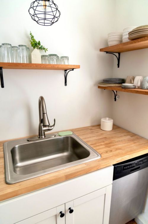 a kitchen with a sink and shelves