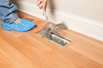 Tech cleaning air duct with brush