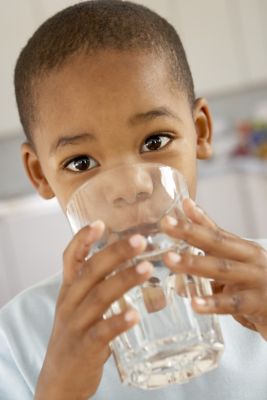Young boy drinking a glass of water