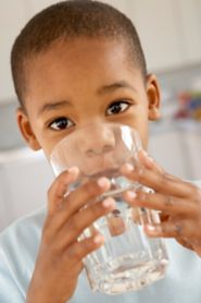 Young boy drinking a glass of water