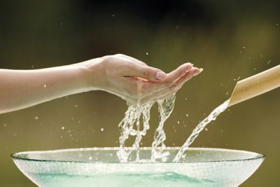 woman-cupping-water-in-her-hand-from-glass-bowl