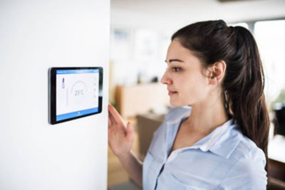 Woman checking her digital thermostat