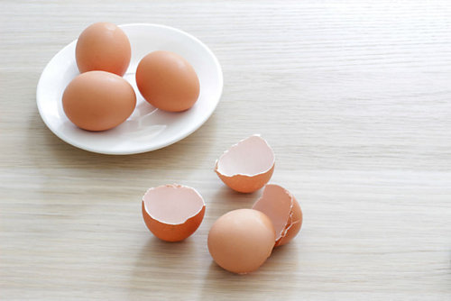 A plate with eggs on it and a plate with eggshells on it