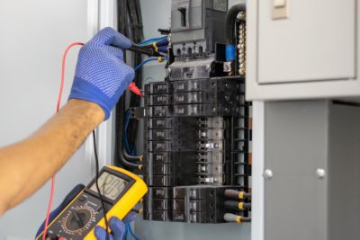 Technician testing an electrical panel 