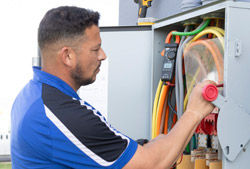 A Coolray electrician checking an electrical panel