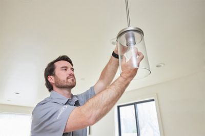 Tech installing hanging light fixture