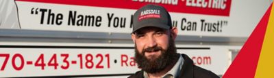 Ragsdale technician smiling in front of house