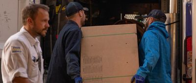 Plumbline employees loading box into truck