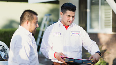 NexGen technicians standing outside a house looking at a clipboard