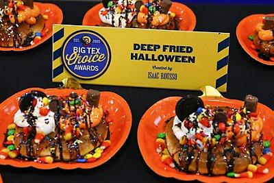 A deep fried halloween dessert with halloween candy on top of a soft pretzel